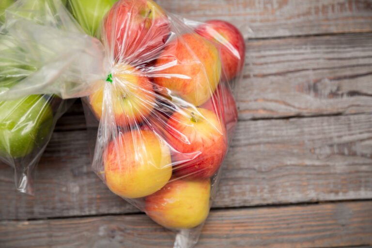 Apple fruit in plastic bag on wood table